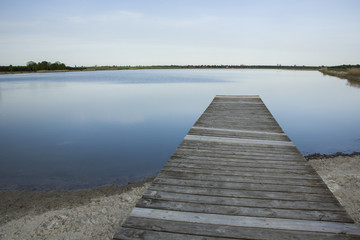 Fototapeta premium Wooden plank bridge to the lake