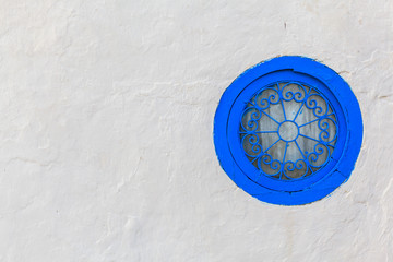 Stylish blue round window on a white wall