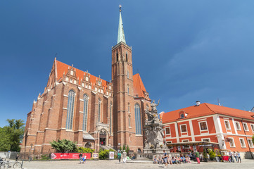 Fototapeta na wymiar Church of the Holy Cross and St Bartholomew and statue of John of Nepomuk in Wroclaw, Poland.