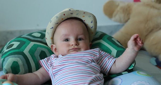 Cute Six Month Old Baby Boy With His Straw Hat Playing With Rattle Toy. Close Up View - DCi 4K Resolution
