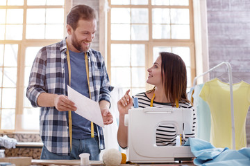 Team brainstorm. Merry two tailors talking about sketch and looking at each other