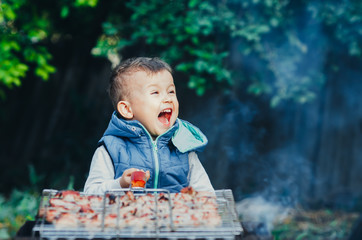 a small child on their own barbecue on the grill helps