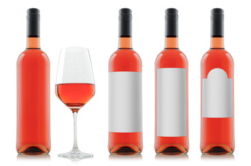 Mock-up sample of filled rose wine bottles with different shaped blank white labels and a glass of wine isolated on white background for individual designs and graphics