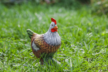 Decorative porcelain chicken on the green grass