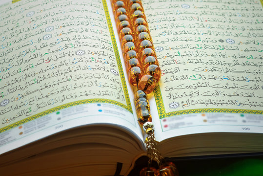Holy islamic book Koran on the draped table with a rosary. Ramadan Kareem beautiful poster, banner, postcard for the celebration of the festival of the Muslim community
