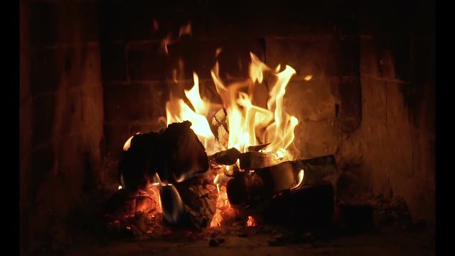 Wood and embers In the fireplace slow motion. Detailed fire background.