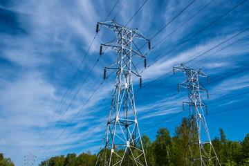 Pylons of high-voltage power lines and a blue sky with clouds