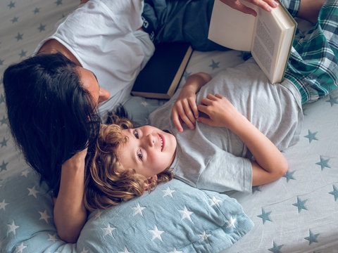 Boy lying with his mother on bed
