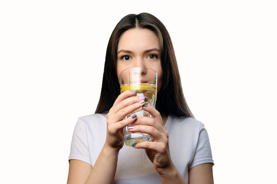 girl drinks water with lemon looks at the camera concept of proper nutrition