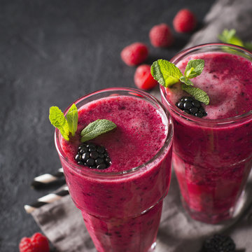 Blackberry and raspberry smoothies in glass with mint leaf and raw beeries