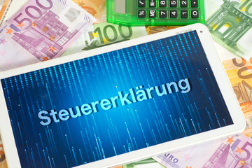 Euro Geldscheine, Taschenrechner und Steuererklärung auf einem Tablet PC