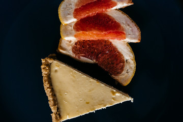 Cheesecake with grapefruit and chocolate on blue plate
