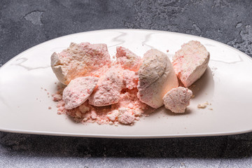 Pink bath salt on black stone background