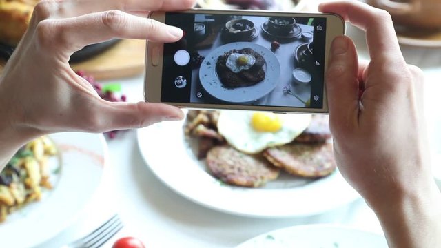 Hands taking photo various dishes with smartphone