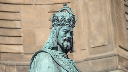 Fototapeta na wymiar Statue of King Charles IV at Charles (Karluv most) Bridge Tower arched gateway in Prague, Czech Republic