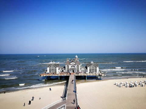 Blick auf den Strand des Ostseebad Sellin mit der ber&uuml;hmten Seebr&uuml;cke auf der Insel R&uuml;gen an der Ostsee bei blauem Himmel und Sonnenschein in Mecklenburg-Vorpommern