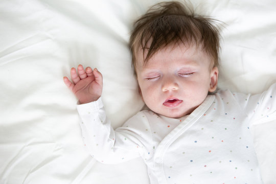 cute baby with dotted body is lying in bed