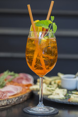 Traditional italian aperitif with proscioutto, mortadella sausage, cheese and aperol spritz drink