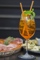 Traditional italian aperitif with proscioutto, mortadella sausage, cheese and aperol spritz drink