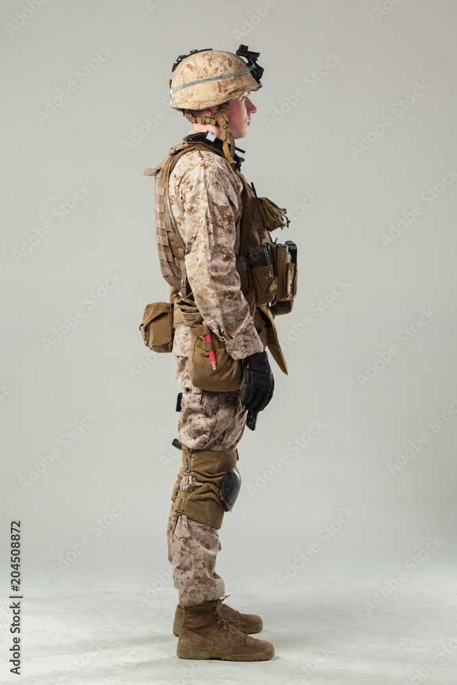 Wall mural Soldier in camouflage holding rifle