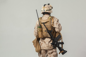 Soldier in camouflage holding rifle