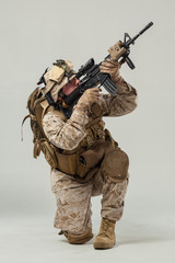 Soldier in camouflage holding rifle