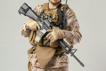 Soldier in camouflage holding rifle
