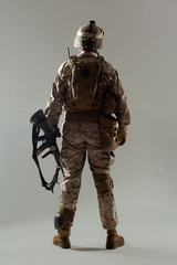 Soldier in camouflage holding rifle