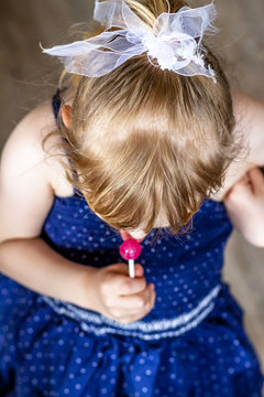 Top view on cutle little blond girl with her lollypop