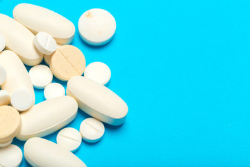 Pills are scattered over a blue background