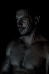 Muscular man in the projection of light points on his body
