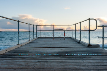 The words "no jetty jumping" at the end of port noarlunga jetty south australia