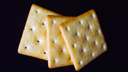 Delicious salty crackers on a black background.