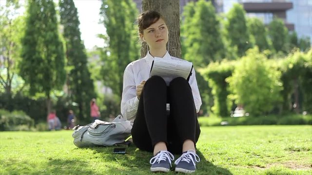 Young woman listening music while reading.