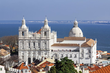 Fototapeta na wymiar Sao Vicente de Fora Monastery, Alfama District orange rooftops and Tagus River estuary. Lisbon, Portugal.