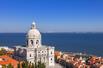 Fototapeta na wymiar Lisbon, Portugal. Panteao Nacional aka Igreja de Santa Engracia Church Alfama District rooftops and Tagus River Estuary. The National Pantheon is a 17th century baroque monument