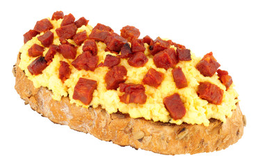 Scrambled eggs with diced chorizo salami on toast isolated on a white background