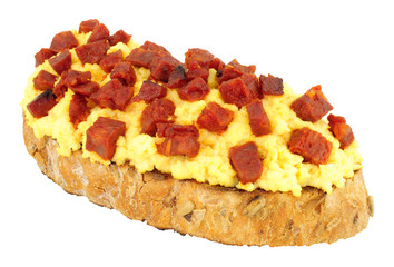 Scrambled eggs with diced chorizo salami on toast isolated on a white background