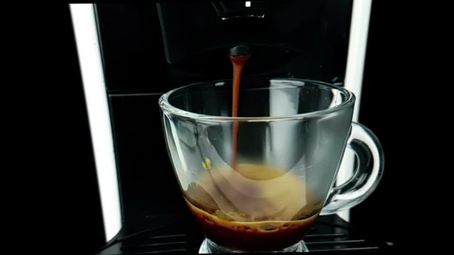 coffee moka machine with hot italian coffee arabica starting go out with foam in slow motion, using a coffee mocha maker machine, breakfast starting concept with a transparent cup of coffee
