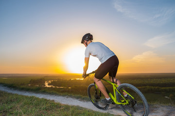 Fototapeta na wymiar Cyclist riding mountain bike on trail at evening. Healthy life style and outdoor adventure.