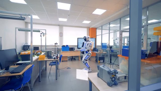 Robot's lights are flashing while it is standing in an office