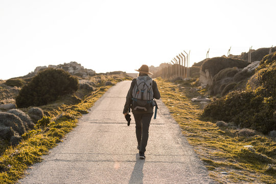 Italy, Sardinia, back view of hiking man with hat and backpack