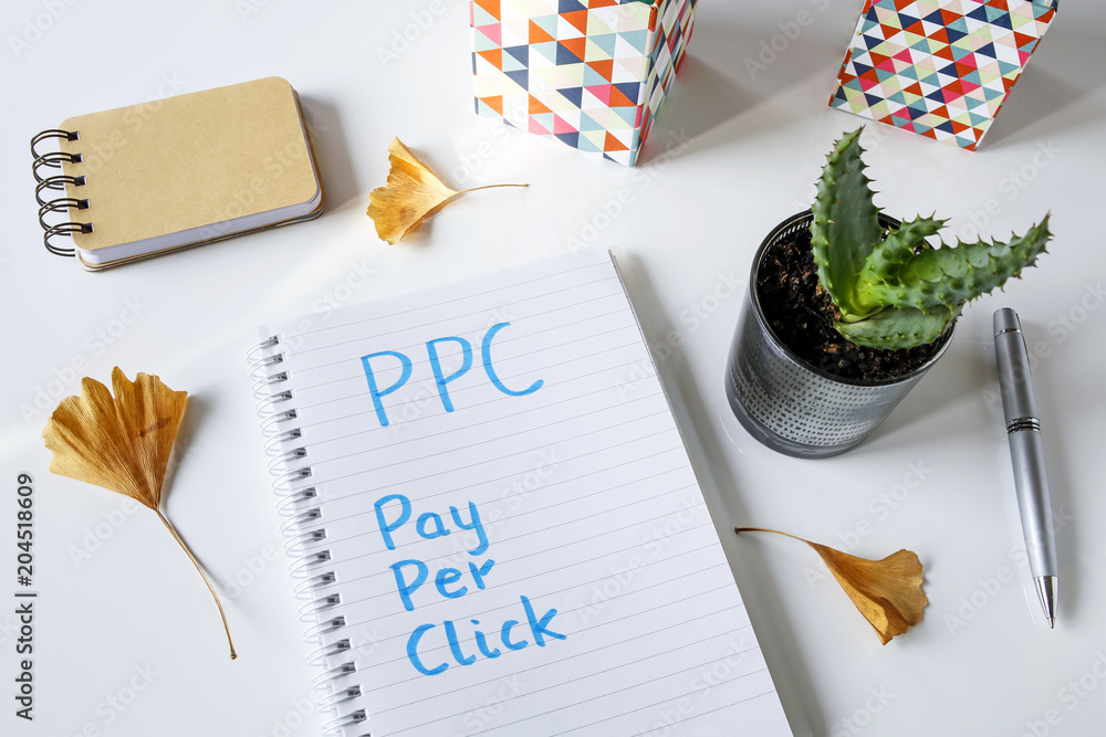 Poster ppc pay per click written in notebook on white table