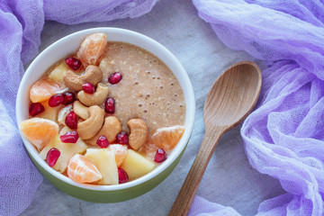 Raw porridge of flax and banana with pineapple, pomegranate, mandarins and cashews