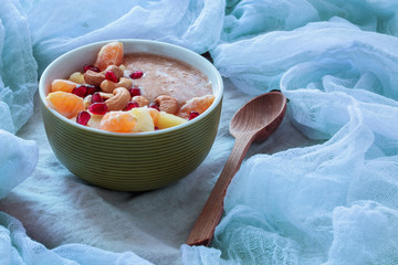 Raw porridge of flax and banana with pineapple, pomegranate, mandarins and cashews