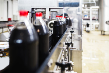 Bottling factory - Orange juice bottling line for processing and bottling juice into bottles. Selective focus. 