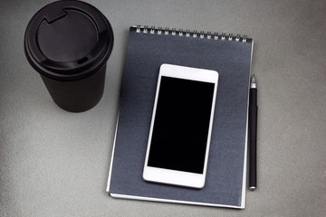 top view coffee to go cup , notepad and cell phone