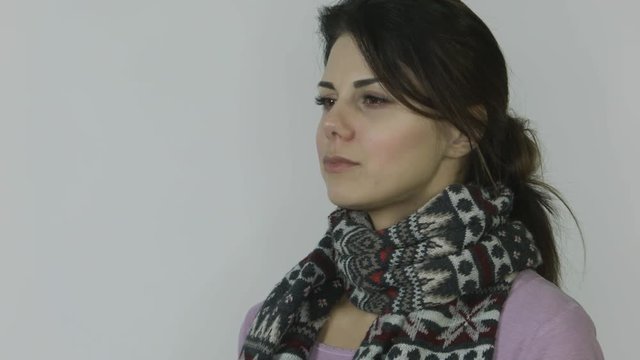 Girl with a runny nose in a scarf with a temperature of drinking cure for the cold