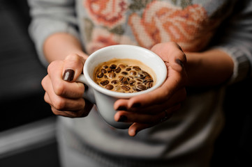 Barista girl holding in her hands a cup of coffee