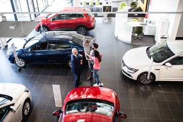 Happy family buying a new car at the car showroom.